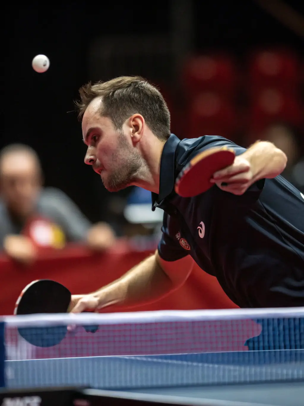 A dynamic image of an advanced player executing a powerful forehand smash during a tournament organized by USTT 12.