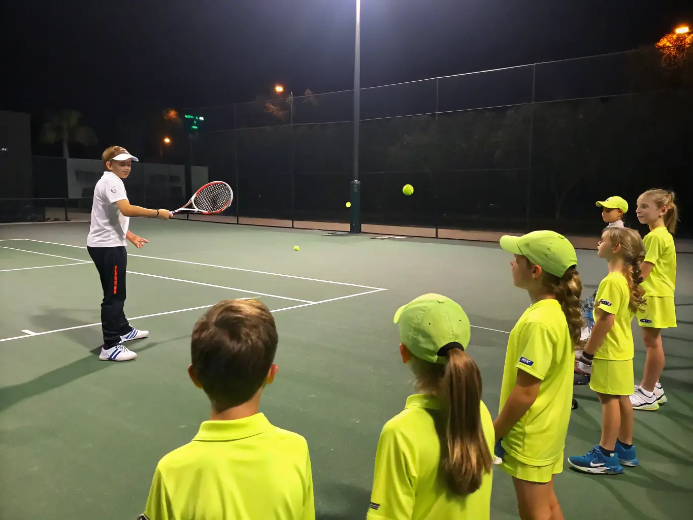 A coach demonstrating proper grip and stroke techniques to a group of players during a training session, emphasizing the importance of fundamentals in table tennis.